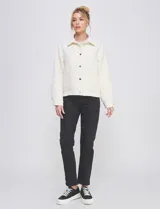 Chaqueta capitoneada de color negro con diseño de rombos, cuello con solapa, cierre frontal con botones metálicos y bolsillos delanteros.