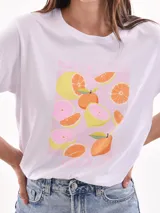 Remera color rosa claro con estampado rectangular de limones y flores.