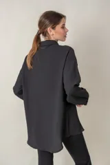 Camisa negra de crepe granulado con spandex, manga larga y corte holgado.