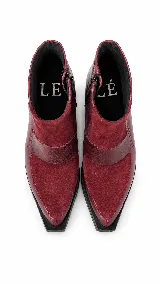 Bota corta de cuero con textura tipo reptil y paneles de gamuza en tono marrón oscuro. Presenta un diseño de punta cuadrada, cierre lateral y un taco cuadrado de madera.