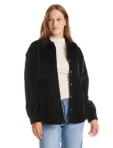 Sobrecamisa de pana con textura acanalada, corte oversize y silueta holgada. Presenta cuello clásico, cierre frontal con botones metálicos, mangas largas con puños abotonados y dos bolsillos frontales tipo parche con solapa.
