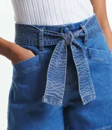 Short de jean azul con cintura alta, cinturón de tela con costuras a la vista y bolsillos.