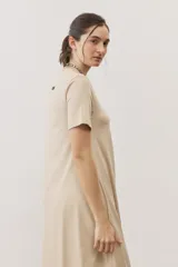 Vestido midi negro con diseño de manga corta, cuello redondo y bolsillos laterales, corte amplio y fluido.