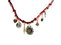 Collar de cordón trenzado rojo y blanco con dijes colgantes variados, incluyendo un gran girasol central con cristales incrustados, un corazón y un pez.