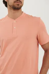 Remera tipo henley de manga corta, color beige, con cuello redondo y cartera de botones frontal.