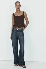 Top corto de tejido de punto color marrón oscuro, con escote cuadrado y tirantes anchos. Presenta un detalle de calado tipo crochet en el ruedo con borde festoneado.