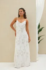 Vestido largo blanco de lino con tirantes finos, escote en V y delicado bordado plateado con motivos florales y brillantes en toda la prenda.