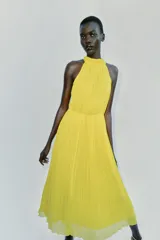 Vestido midi amarillo con diseño plisado, cuello halter y cintura elástica.