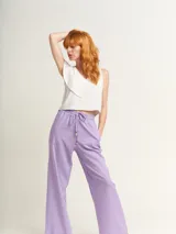 Pantalón de lino color lila, tiro alto, corte palazzo con elástico en la pretina, bolsillos laterales y dobladillo invisible.