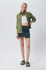 Minifalda de jean negra con corte asimétrico en el frente y deflecado tanto en la cintura como en el ruedo.