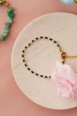 Tobillera dorada de acero quirúrgico con circonitas turquesas y blancas.