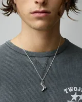Collar de cadena fina con dije colgante en forma de bota vaquera con detalles grabados, acabado en color plata envejecida.