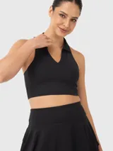 Top deportivo tipo polo de corte cropped, con cuello clásico y escote en V. Presenta un diseño ajustado al cuerpo y espalda estilo nadadora.