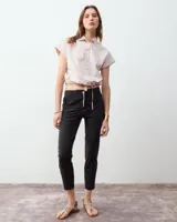 Pantalón cigarette blanco de tela techno italiana, tiro medio, cintura elastizada en la espalda, cierre y snap metálico en delantero, bolsillos laterales con cierre y recorte en la pierna con cierre en la botamanga.