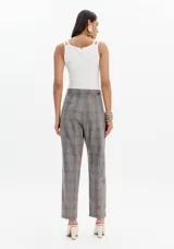 Pantalón gris a cuadros con corte baggy, cintura alta y dos botones decorativos.
