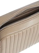 Bandolera Calvin Klein color beige con diseño acolchado a rayas verticales, logo metálico plateado en el frente y correa de cuero con cadena plateada.