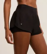 Bermuda deportiva tipo runner, color verde menta, confeccionada en microfibra con cintura elástica. Tiene un corte holgado y bajo redondeado.