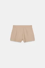 Shorts de tiro medio con bolsillos laterales y detalle de pinzas delanteras. Cierre frontal con cremallera, botón interior y gancho metálico.