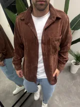 Sobrecamisa de pana color marrón chocolate, con cuello clásico, cierre frontal de botones y un bolsillo en el pecho.