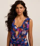 Vestido corto de playa confeccionado en tule estampado de flores coloridas, con mangas cortas, escote en V y detalle de torcedura en la parte delantera.