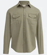Camisa verde militar de manga larga en sarga de algodón, con cuello clásico, cierre frontal abotonado y dos bolsillos con solapa abotonada en el pecho.