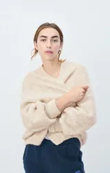 Cárdigan corto de punto color negro, con mangas largas y corte holgado.