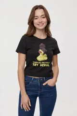 Remera blanca de manga corta, con estampa frontal de un pato de hule con turbante y labios pintados, acompañada de la frase "In all else fails, denial".