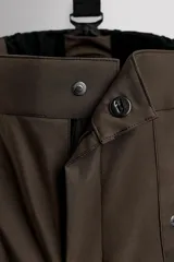 Pantalón deportivo de esquí color negro, confeccionado en tejido técnico impermeable de tres capas con costuras y cremalleras termoselladas. Cuenta con tirantes elásticos regulables, cintura ajustable, bolsillos frontales con cierre, refuerzos en la parte inferior de la pernera y sistema de rescate RECCO integrado.