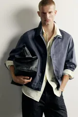 Sobrecamisa de corte relaxed fit confeccionada en tejido de mezcla de lyocell y algodón, en color azul oscuro con efecto lavado. Presenta cuello camisero, manga larga con puños abotonados, bolsillos frontales de vivo y cierre central de botonadura.