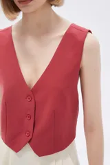 Top tipo chaleco de corte entallado, con escote en V y cierre frontal con botones a tono.