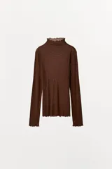 Camiseta marrón de tejido traslúcido con lyocell y lana, cuello alto con volados y mangas largas con volados en los puños.