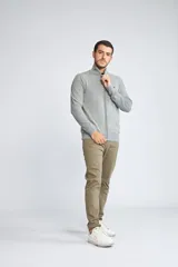 Campera tejida de algodón con cierre frontal completo, cuello alto y mangas largas. Presenta un diseño básico con logo bordado en el pecho.