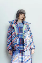 Campera puffer con estampado a cuadros en tonos azul, rojo, amarillo y blanco. Diseño capitoneado a mano y forro interior verde. Corte holgado. Ideal para usar con un look casual.