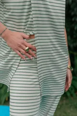 Conjunto de dos piezas de tejido rib con patrón de rayas horizontales blancas y verde militar, compuesto por una remera de manga corta con abertura frontal y un pantalón de corte recto y holgado.