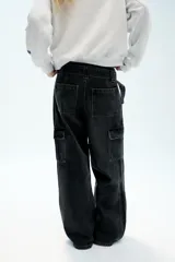 Pantalón cargo de tiro medio confeccionado en denim marrón oscuro. Presenta bolsillos laterales con solapa, bolsillos clásicos y un cinturón integrado del mismo tejido con hebilla metálica.