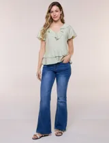 Blusa de satén texturizado color verde menta, con escote en V y volados que bordean el cuello. Presenta mangas cortas acampanadas y doble nivel de volados en la parte inferior, formando una silueta péplum.