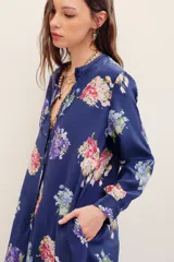 Camisa larga azul marino con estampado de ramos de flores coloridas, cierre frontal de botones y mangas largas.