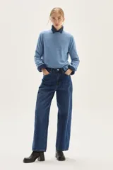 Sweater de punto color beige, con cuello redondo, manga larga y puños acanalados.