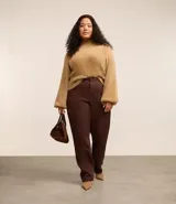 Suéter color beige de punto con textura de pelitos, cuello alto y mangas largas.