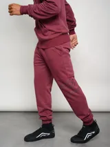 Pantalón de jogging azul marino de felpa con puños elásticos y logo de la marca estampado en la pierna izquierda.