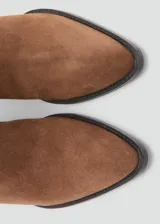 Bota de caña alta estilo cowboy confeccionada en piel de serraje color marrón, con tacón rectangular y punta fina.