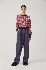 Pantalón de gabardina liviana de algodón color azul marino, de tiro alto con pinzas delanteras que generan volumen, bolsillos americanos y acceso frontal con cartera con cierre metálico.