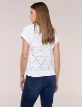 Buzo de tejido de algodón color blanco, de silueta semi holgada, con motivos de calados geométricos y guardas en zigzag. Cuenta con escote redondo, mangas cortas estilo japonesa y terminaciones acanaladas.