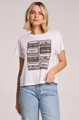 Remera blanca de manga corta y cuello redondo, con estampado frontal de casetes retro en tonos grises.