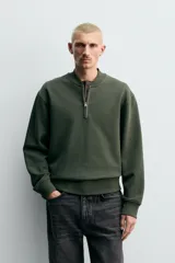 Sudadera de corte regular fit confeccionada en tejido de algodón con interior de rizo. Presenta cuello tipo rib, cierre frontal de cremallera y acabados en rib en puños y bajo.