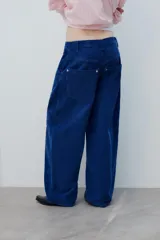 Pantalón de tiro medio confeccionado en pana color azul, de corte baggy con pierna ancha, estilo clásico de cinco bolsillos y cierre frontal con cremallera y botón metálico.