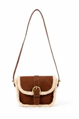 Cartera tipo bandolera color marrón con detalles de piel sintética color crema en los bordes. Tiene una solapa frontal con cierre de hebilla dorada y correa fina ajustable.