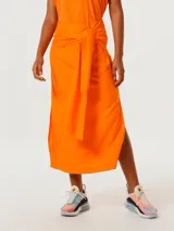 Pollera midi color naranja con lazo en la cintura y abertura lateral.