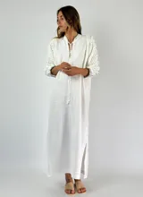 Vestido largo blanco de lino con mangas tres cuartos con detalle de crochet.