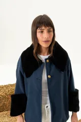 Sobre camisa azul marino en paño de lana con cuello y puños en cuero napalan negro, con botones dorados.